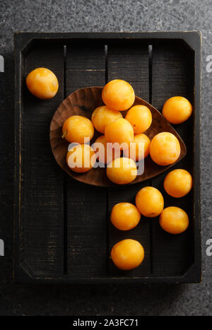 Dolce estate prugne giallo sul vassoio in legno Vista superiore Foto Stock