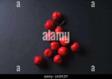 Rosso ciliegio dolce prugne su sfondo scuro. Vista aerea Foto Stock