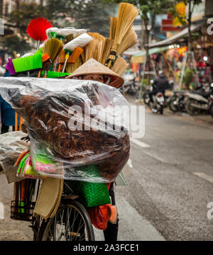 Mattina scena di strada di Hanoi: portare merci sul mercato in sella a una moto Foto Stock