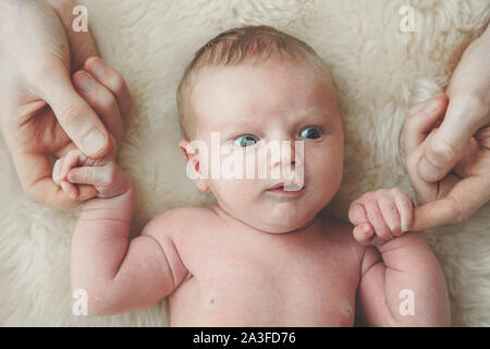 Un simpatico baby detiene sul dito di padri. Concetto di paternità Foto Stock