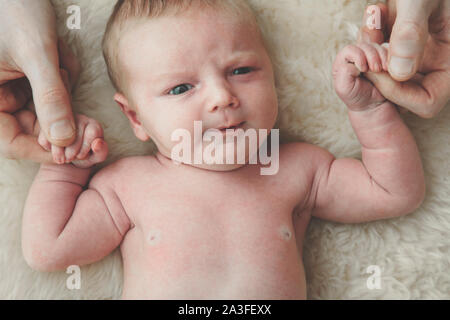 Un simpatico baby detiene sul dito di padri. Concetto di paternità Foto Stock