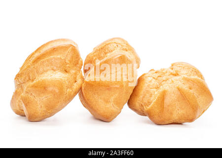 Gruppo di tre interi cotta profiterole dorata in linea isolati su sfondo bianco Foto Stock