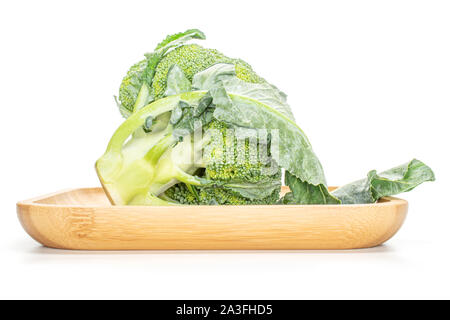 Un intero fresco verde broccoli su legno piastra quadrata isolati su sfondo bianco Foto Stock