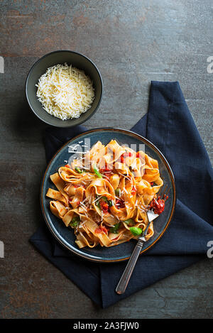 Gustosi piatti appetitosi in classico stile italiano la pasta con la salsa di pomodoro e formaggio parmigiano e basilico sulla piastra. Vista da sopra Foto Stock