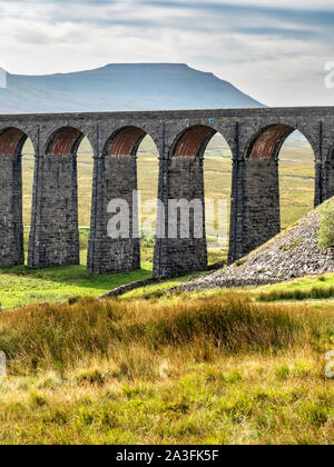 Gli archi del viadotto Ribblehead con Ingleborough al di là di Yorkshire Dales National Park in Inghilterra Foto Stock