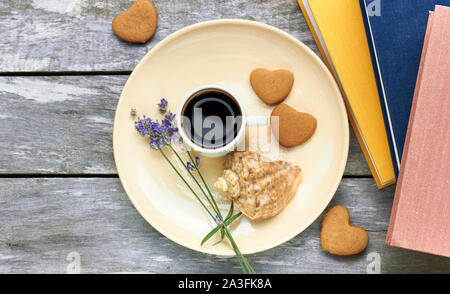 Vacanza scandinavo colazione al mare: caffè, a forma di cuore i cookie, lavanda, shell e libri sul vecchio weathered tavolo in legno, gustare un semplice momento Foto Stock