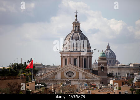 Una vista sui tetti del centro di Roma, Italia. La cupola di Santi Ambrogio e Carlo e la Basilica di San Pietro si vedono contro un cielo tempestoso. Foto Stock