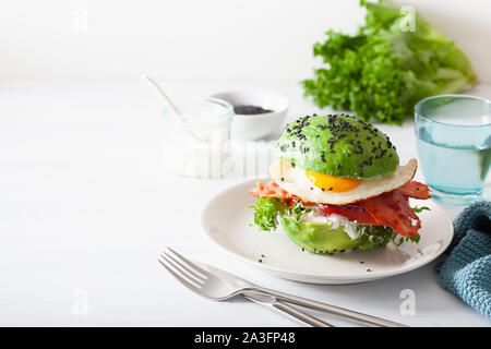 Cheto paleo dieta colazione avocado burger con pancetta, uova, pomodori Foto Stock