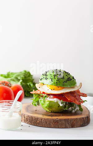 Cheto paleo dieta colazione avocado burger con pancetta, uova, pomodori Foto Stock