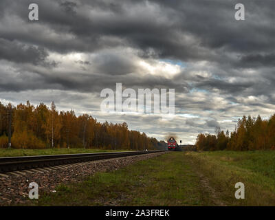 La strada ferrata contro lo sfondo di un azzurro cielo di autunno va all'infinito. Foto Stock