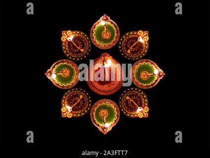 Diwali, la festa indù delle luci celebrazione. Clay diya illuminate in Dipavali, tradizionali lampade ad olio su sfondo scuro, vista dall'alto Foto Stock