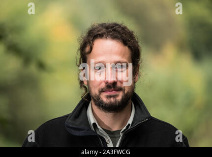 Bad Sobernheim, Germania. 07 ott 2019. Bernhard Frauenberger, Foresta Office Manager Soonwald, sorge nella foresta. Un piegato conifera albero sorge su uno spazio aperto che è stato creato dalla rottura del vento. Durante una escursione, Ministero dell'ambiente della Renania Palatinato ha spiegato lo sviluppo della foresta di fronte al cambiamento climatico. Credito: Andreas Arnold/dpa/Alamy Live News Foto Stock