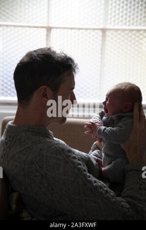 Padre consolante un pianto sconvolto baby. La paternità, concetto di Parenting Foto Stock