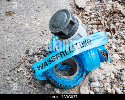 Via Nastro di avvertenza tubo acqua con tubo di acqua Foto Stock