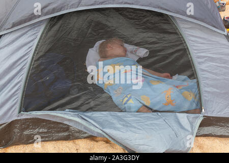 Bimbo di 2 anni dormono in una spiaggia sun tenda , speranza esterno Cove, Mouthwell sands beach, Kingsbridge, Devon, Inghilterra, Regno Unito. Foto Stock