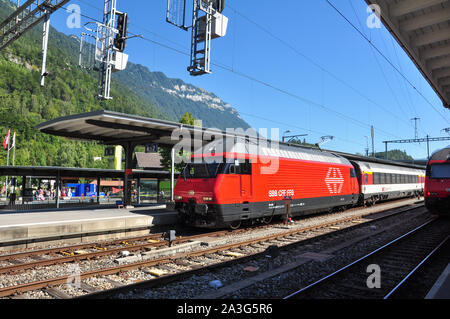 Classe Re 460 locomotiva elettrica con un express treno passeggeri a Interlaken Ost stazione ferroviaria, Oberland bernese, Svizzera Foto Stock