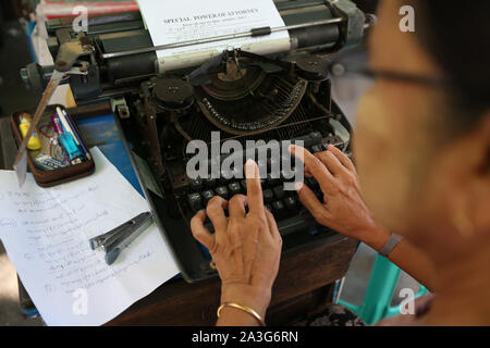 Yangon, Myanmar. 1 Ott 2019. Un dattilografo tipi fuori un contratto legale di Yangon, Myanmar, 1 ottobre, 2019. Clickety-clack suoni provenienti da macchine da scrivere sono sentito lungo una trafficata strada vecchia nell'area del centro cittadino di Myanmar di Yangon, portando vibes indietro dalla passata epoca d'oro di macchine da scrivere. Credito: U Aung/Xinhua/Alamy Live News Foto Stock