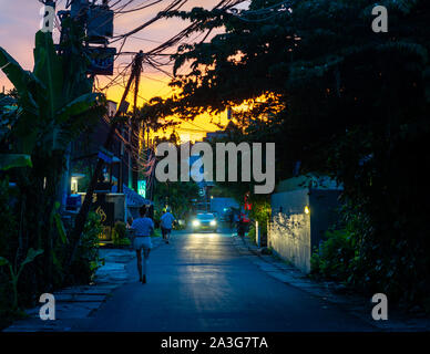 Piccola strada in Seminyak al tramonto, in Bali, Indonesia Foto Stock