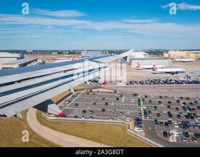 Vista dalla finestra del piano di sopra il parcheggio e hangar s sulla rotta di avvicinamento all'aeroporto di Heathrow di Londra, Inghilterra, Regno Unito Foto Stock
