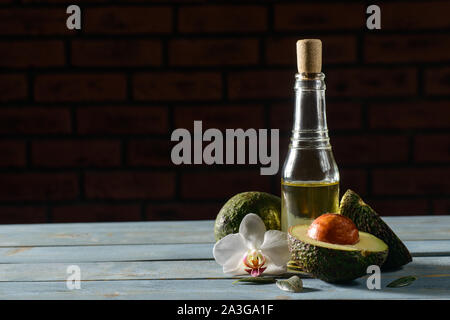 Ancora in vita con olio di avocado bottiglia su tavola in legno tabella Foto Stock