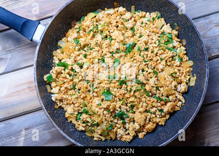 La preparazione di carne macinata. , Di pollo o di manzo Turchia tritare rosolare in padella su uno sfondo di legno. Foto Stock