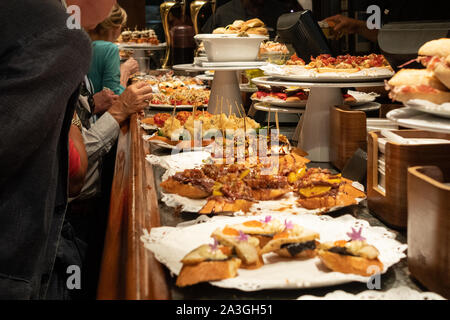 Pintxos essendo servita a Casa Gandarias, un popolare Pintxos bar e ristorante a San Sebastian, Paesi Baschi, Spagna, Europa Foto Stock