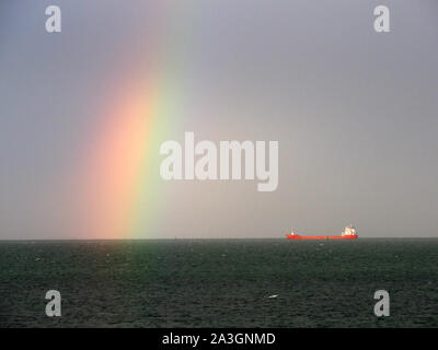 Sheerness, Kent, Regno Unito. 8 Ottobre, 2019. Regno Unito: Meteo nave cargo Reggedijk raffigurato sotto una vivace arcobaleno nel Sheerness, Kent durante un pomeriggio con doccia a pioggia. Credito: James Bell/Alamy Live News Foto Stock