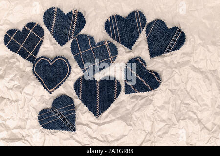 Fatto a mano Jeans cuori su un accartocciata craft lo sfondo della carta. Appartamento laico, vista dall'alto, stile minimal, copia spazio per il testo. Simbolo di amore, per San Valentino d Foto Stock