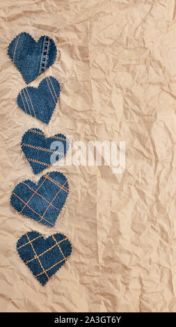 Fatto a mano Jeans cuori su un accartocciata craft lo sfondo della carta. Appartamento laico, vista dall'alto, stile minimal, copia spazio per il testo. Simbolo di amore, per San Valentino d Foto Stock