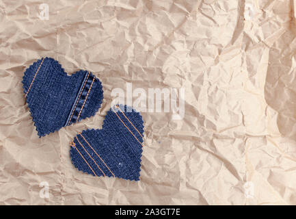 Fatto a mano Jeans cuori su un accartocciata craft lo sfondo della carta. Appartamento laico, vista dall'alto, stile minimal, copia spazio per il testo. Simbolo di amore, per San Valentino d Foto Stock