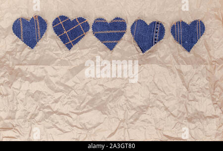 Fatto a mano Jeans cuori su un accartocciata craft lo sfondo della carta. Appartamento laico, vista dall'alto, stile minimal, copia spazio per il testo. Simbolo di amore, per San Valentino d Foto Stock