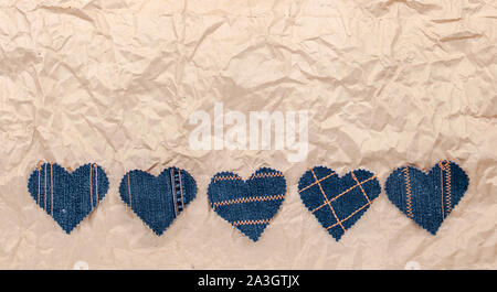 Fatto a mano Jeans cuori su un accartocciata craft lo sfondo della carta. Appartamento laico, vista dall'alto, stile minimal, copia spazio per il testo. Simbolo di amore, per San Valentino d Foto Stock