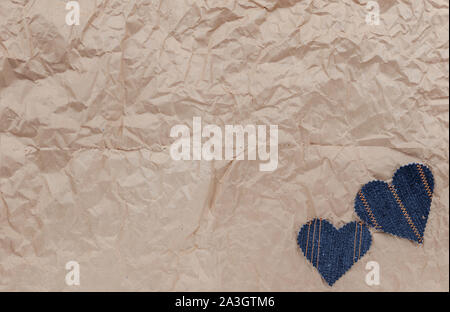 Fatto a mano Jeans cuori su un accartocciata craft lo sfondo della carta. Appartamento laico, vista dall'alto, stile minimal, copia spazio per il testo. Simbolo di amore, per San Valentino d Foto Stock