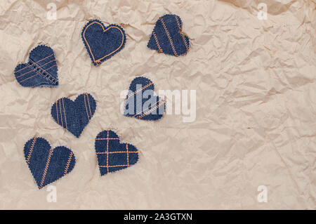 Fatto a mano Jeans cuori su un accartocciata craft lo sfondo della carta. Appartamento laico, vista dall'alto, stile minimal, copia spazio per il testo. Simbolo di amore, per San Valentino d Foto Stock