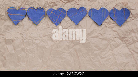 Fatto a mano Jeans cuori su un accartocciata craft lo sfondo della carta. Appartamento laico, vista dall'alto, stile minimal, copia spazio per il testo. Simbolo di amore, per San Valentino d Foto Stock