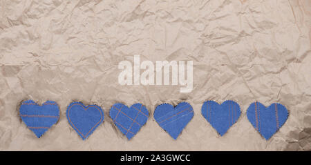 Fatto a mano Jeans cuori su un accartocciata craft lo sfondo della carta. Appartamento laico, vista dall'alto, stile minimal, copia spazio per il testo. Simbolo di amore, per San Valentino d Foto Stock