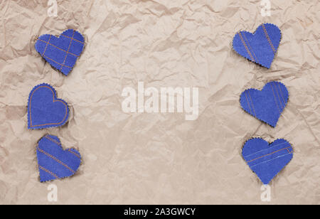 Fatto a mano Jeans cuori su un accartocciata craft lo sfondo della carta. Appartamento laico, vista dall'alto, stile minimal, copia spazio per il testo. Simbolo di amore, per San Valentino d Foto Stock