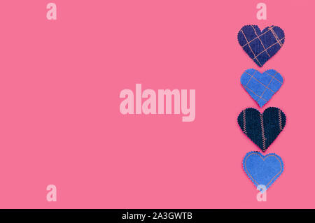 Fatto a mano Jeans cuori su uno sfondo di colore rosa. Appartamento laico, vista dall'alto, stile minimal, copia spazio per il testo. Simbolo dell amore per il giorno di San Valentino biglietto di auguri Foto Stock