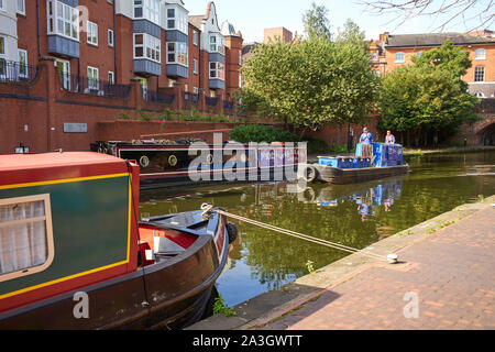 Un canale e il fiume fiducia workboat passa ormeggiati narrowboat William n102 nel centro di Birmingham Foto Stock