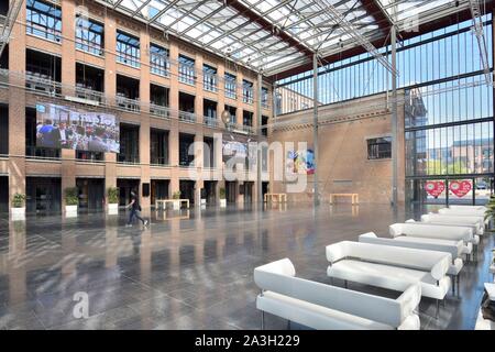 Francia, Nord, Lille, distretto di Bois Blancs, EuraTechnologies business park polo di eccellenza dedicato alle TIC della metropoli di Lille svolge nel Blan Lafont che è una vecchia filanda costruito nel 1900, l'uomo nella sala di ingresso dove sono disposti divani bianchi Foto Stock