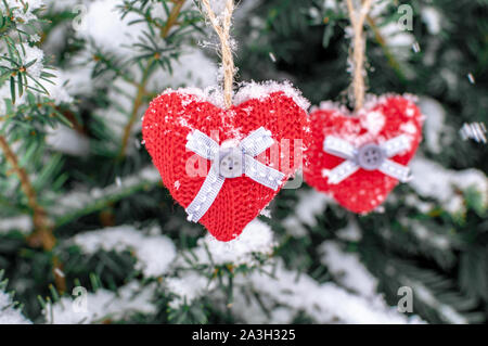 Due cuori a maglia appeso su un ramo. Simbolo di amore e il giorno di San Valentino festa.. Foto Stock
