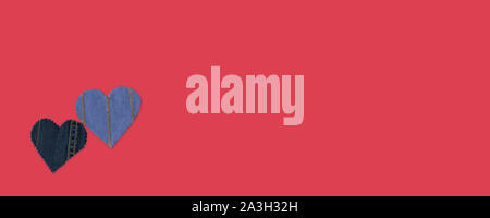 Fatto a mano Jeans cuori su sfondo rosso. Appartamento laico, vista dall'alto, stile minimal, copia spazio per il testo. Simbolo dell amore per il giorno di San Valentino biglietto di auguri o Foto Stock