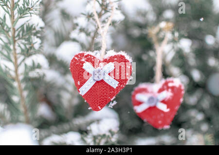 Due cuori a maglia appeso su un ramo. Simbolo di amore e il giorno di San Valentino festa.. Foto Stock