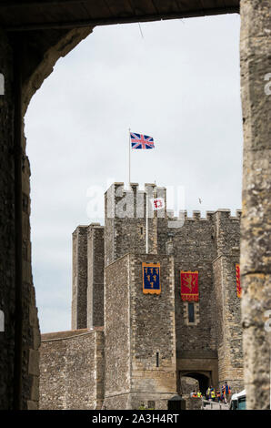 White Bird attorno alla terra su Union Jack flag pole, bandiera in una giornata di sole oltre il castello di Dover, Kent England. Tetto a merli del castello di mantenere. Foto Stock