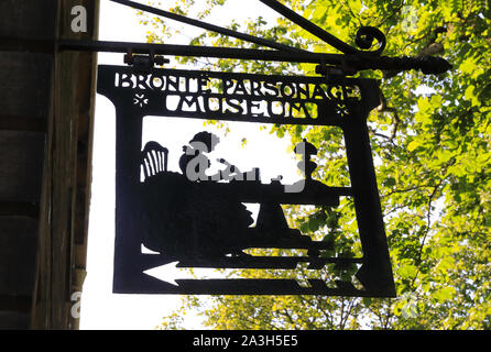 Segno per il Bronte Parsonage Museum, in onore delle sorelle Bronte, Charlotte, Anne & Emily, sulla chiesa St, in Haworth, West Yorkshire, Regno Unito Foto Stock