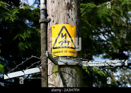 Pericolo di morte segno su un legno traliccio di elettricità Foto Stock