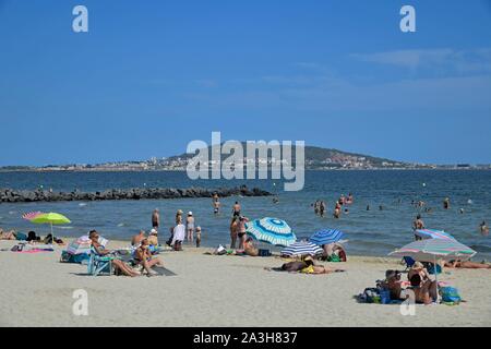 Francia, Herault, Meze, vacanzieri su una spiaggia di La laguna di Thau con il Mont Saint Clair in background Foto Stock