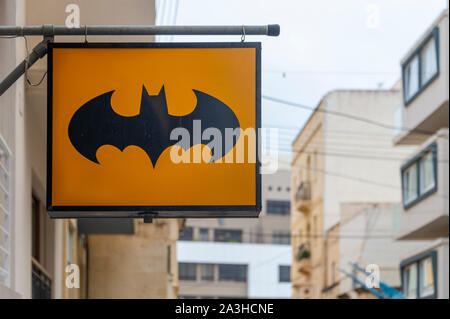 Illuminato il simbolo di Batman al di sopra di un negozio Foto Stock