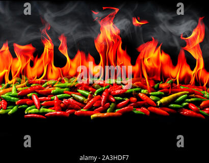 Gruppo di red hot chili pepper sul fuoco e il fumo a sfondo nero Foto Stock