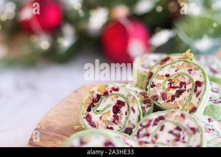 Freschi Fatti in casa a base di mirtillo palustre pinwheels fatta con crema di formaggio, di mirtilli rossi secchi, noci, formaggio di capra e rosmarino pronto per le vacanze. Foto Stock